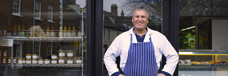 Male baker standing in front of bakery