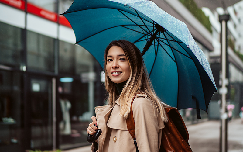 Woman holding umbrella in rainy weather