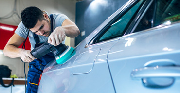 Man buffing car at auto detail shop