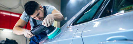 Man buffing car at detail shop