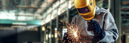 Welder wearing a yellow protective helmet