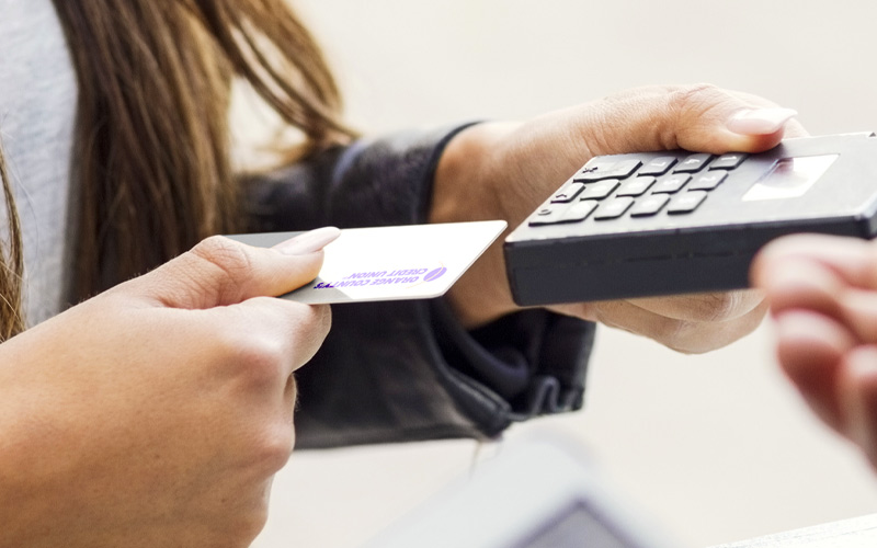 Person paying with debit card at pay station