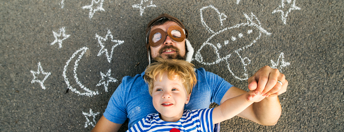 Father and child playing on sidewalk