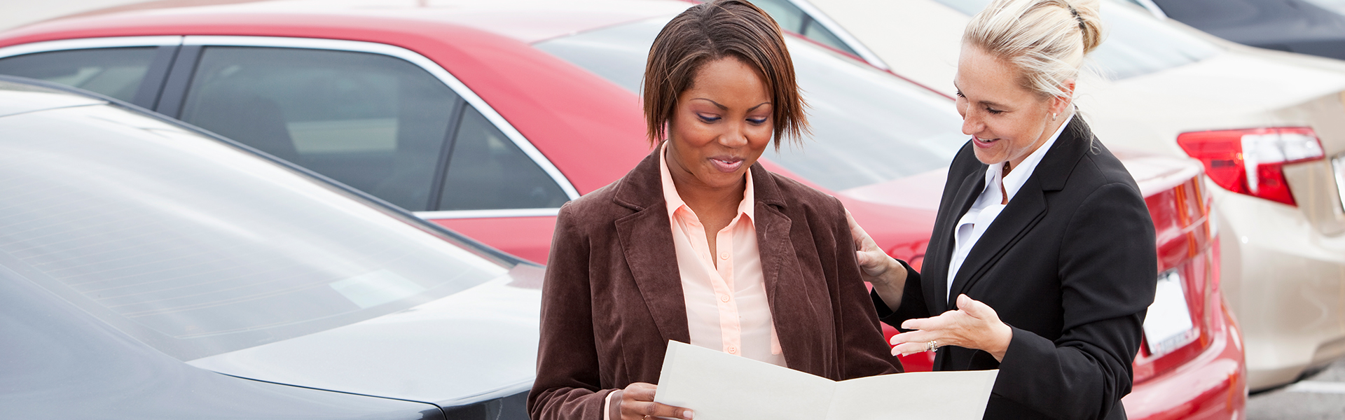 Photo of a woman interested in buying a vehicle looking at a sales contract