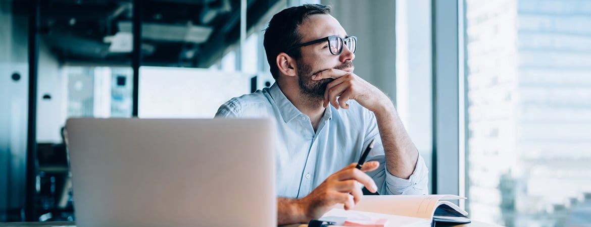 Business person looking contemplatively out of window