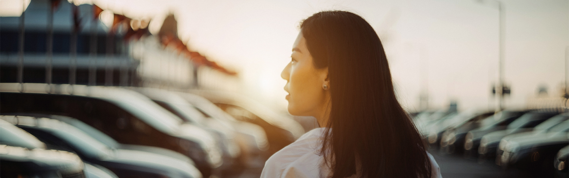 woman walking down car aisle at car lot